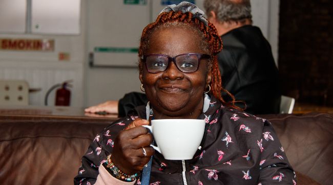 A photo of a woman holding a cup of coffee