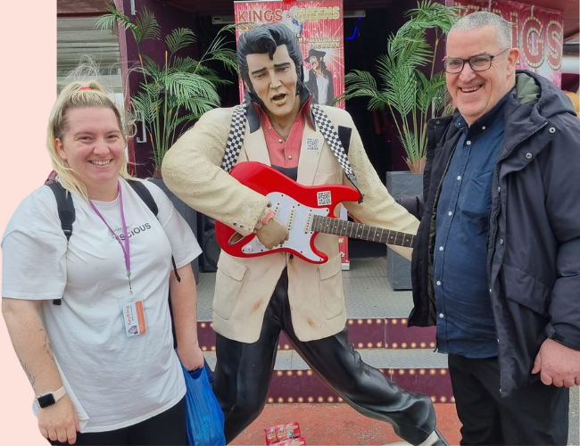A photo of a KeyRing worker and a Member standing either side of a statue of Elvis