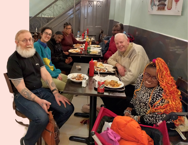 A group of Members and staff sitting at a table in a restaurant